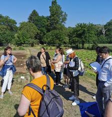 Groupe de personnes dans un jardin en train d'écouter une personne